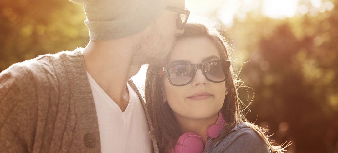 Hombre besando a una mujer en un parque