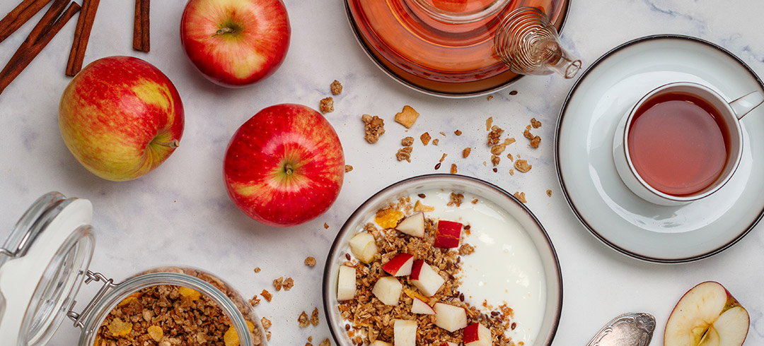 Desayuno sobre una mesa con café y un bowl con fruta, cereales y yogurt