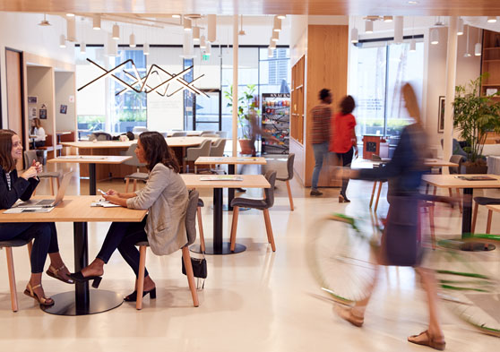 Personas trabajando y transitando en un local de oficina