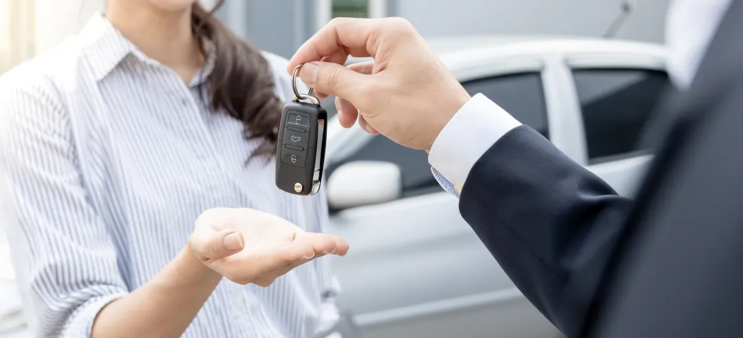 Persona dando las llaves de un coche en la mano de otra persona